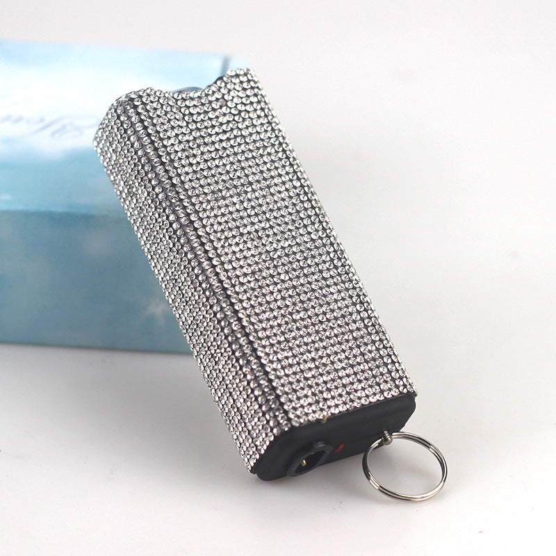 Decorative flashlight with rhinestone embellishments on a white surface.