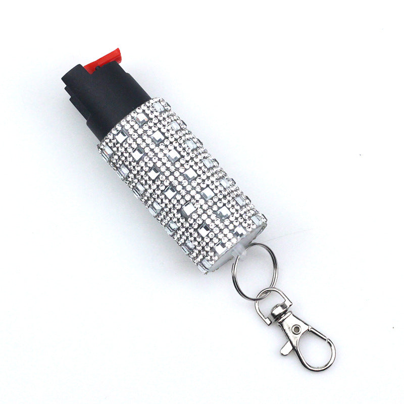 Pepper spray with rhinestone cover and keychain on a white background