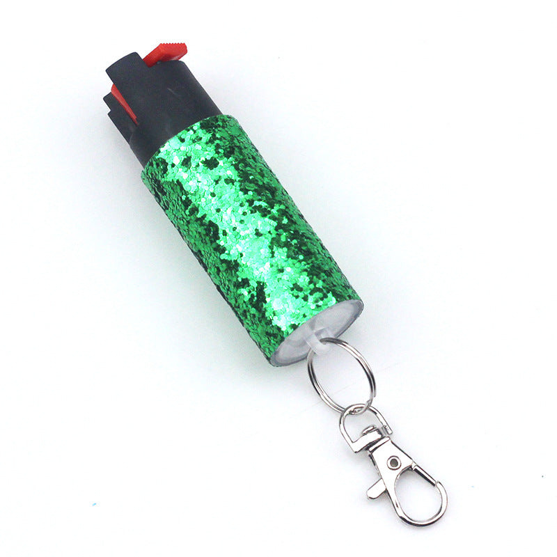 Green glittery lighter with a pepper spray keychain on a white background