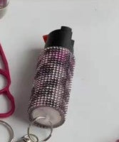 Pepper spray with black handle and pink accents on a white background