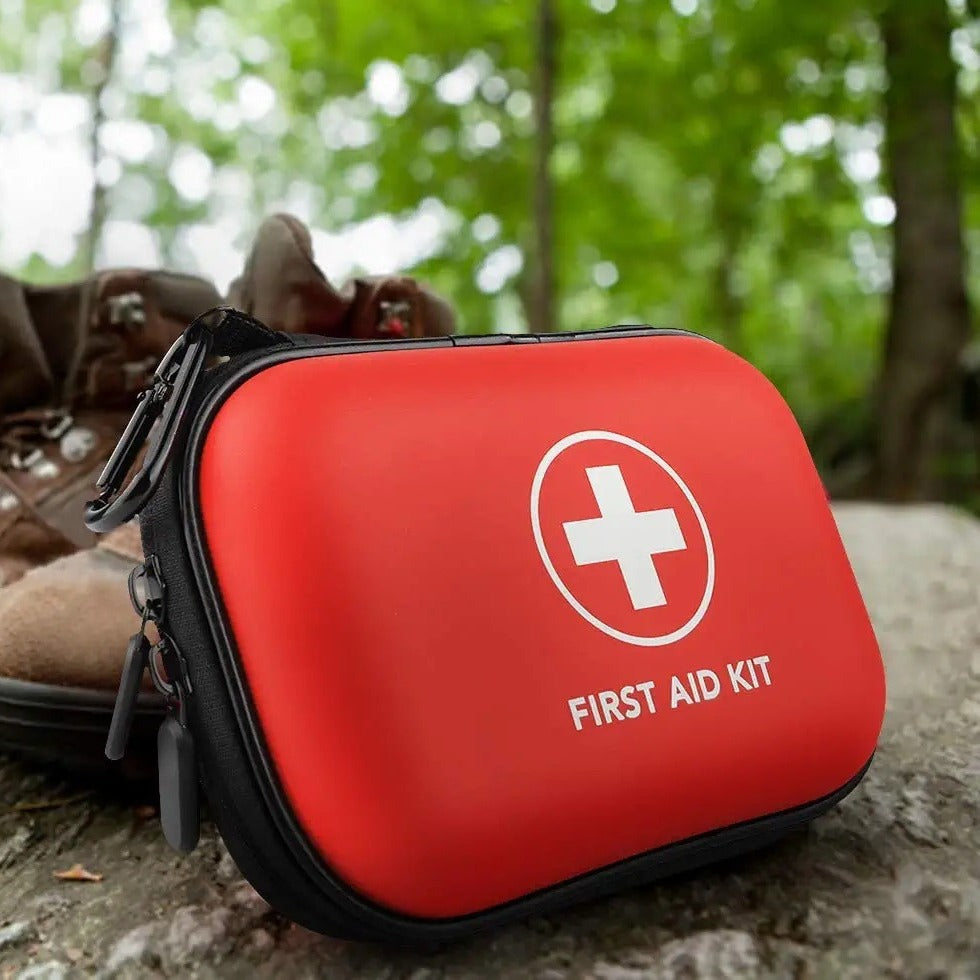 Red first aid kit with a white cross symbol on a natural background