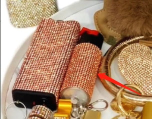 Collection of small items including a phone case, pepper spray keychain, and decorative objects on a white surface.
