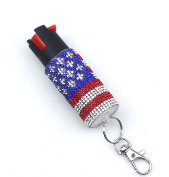 Pepper spray with American flag design and keychain on a white background
