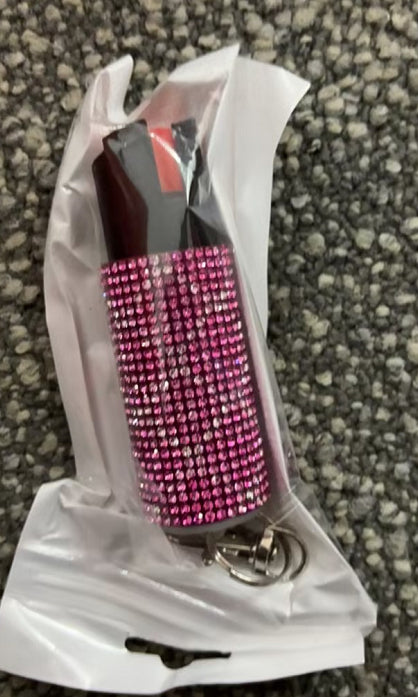 Pink rhinestone-laden object on a textured surface