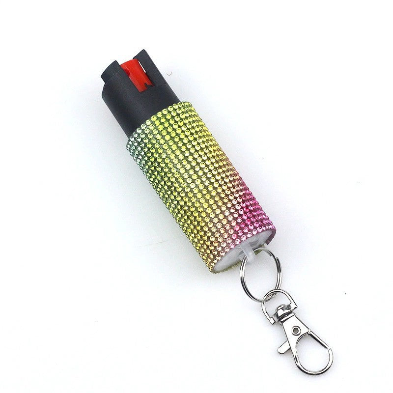Pepper spray with rhinestone cover and keychain on a white background