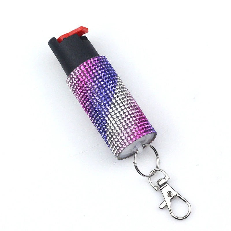 Pepper spray with rhinestone cover and keychain on a white background
