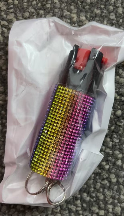 Colorful keychain with rhinestones on a white plastic bag against a textured surface.