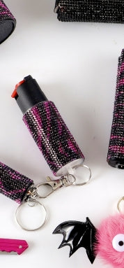 Decorative pepper spray with black and pink accents on a white background