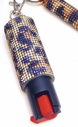 Keychain with a blue and gold patterned container and red button