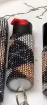 Two black and red pepper spray with a textured pattern on a white background