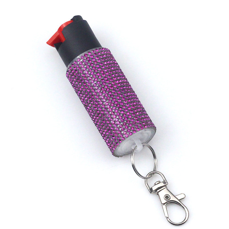  pepper spray with pink glittery cover and keychain attachment on a white background