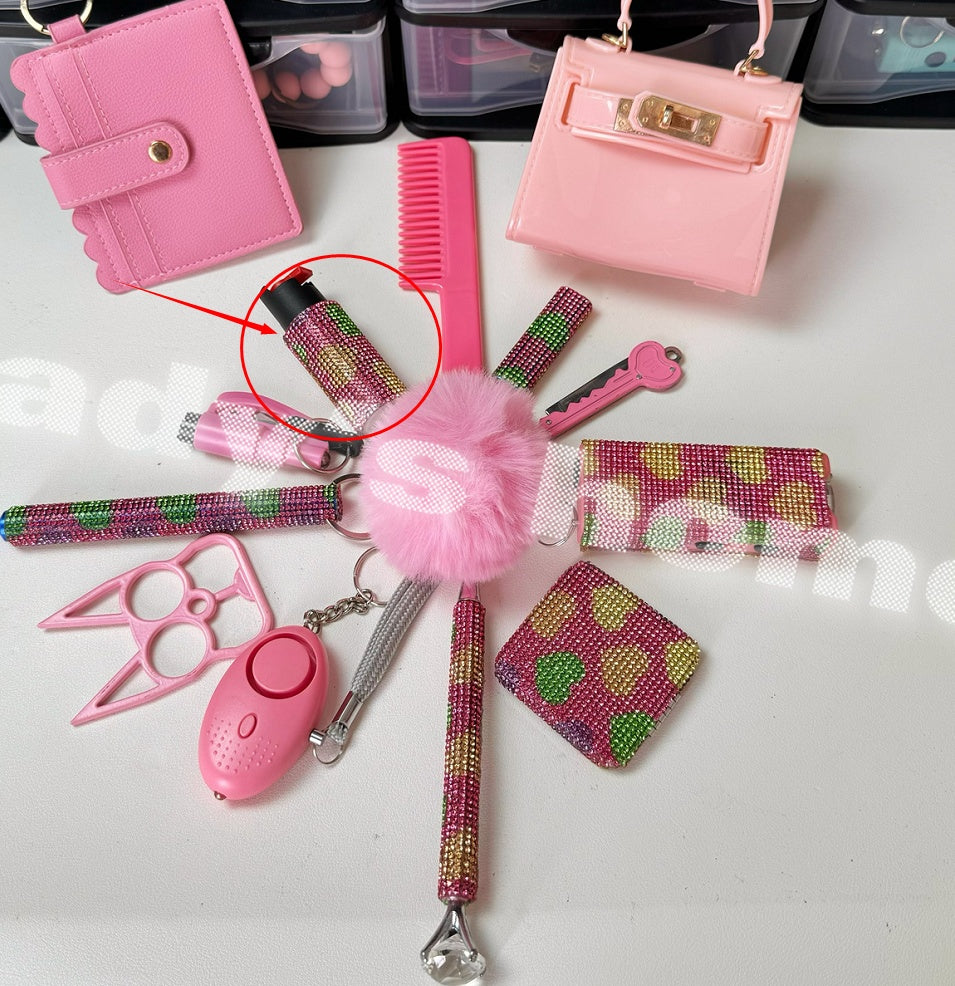 Collection of pink accessories including a wallet, purse, comb, and keychain on a white surface.