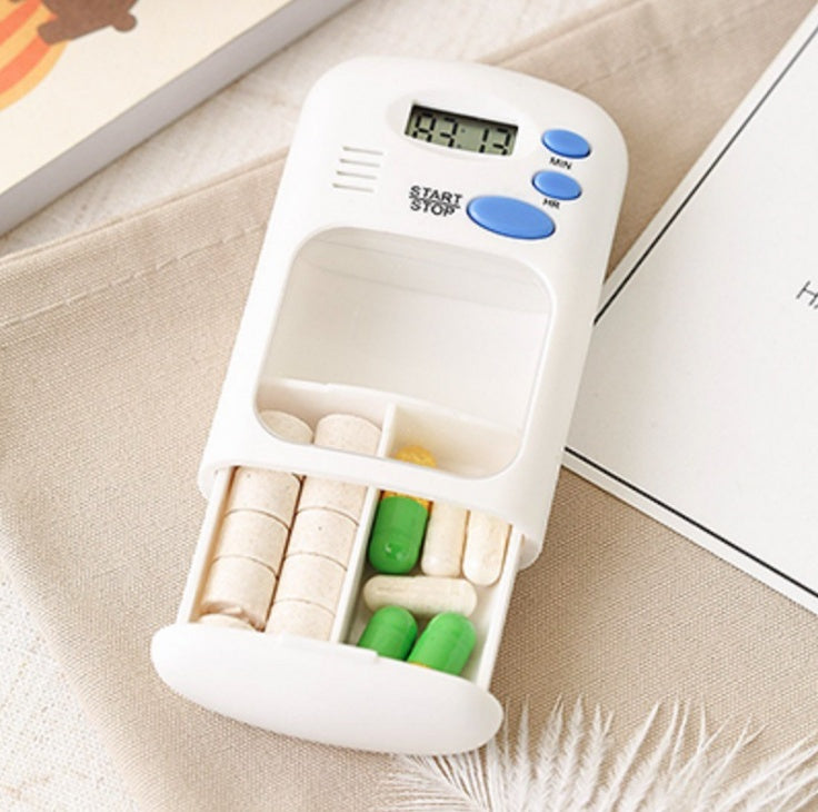White pill organizer with compartments filled with pills on a beige surface