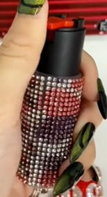 Close-up of a hand holding a colorful pepper spray with a blurred background