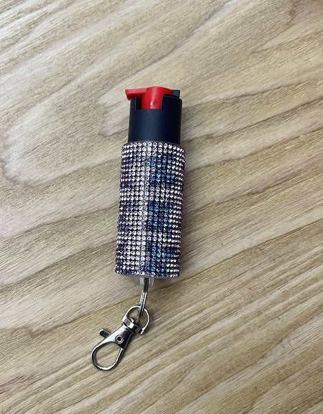 pepper spray in a silver bling on a wooden surface