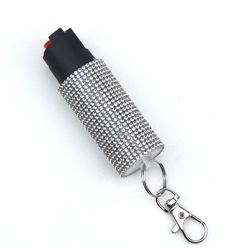 Pepper spray with rhinestone cover and keychain on a white background